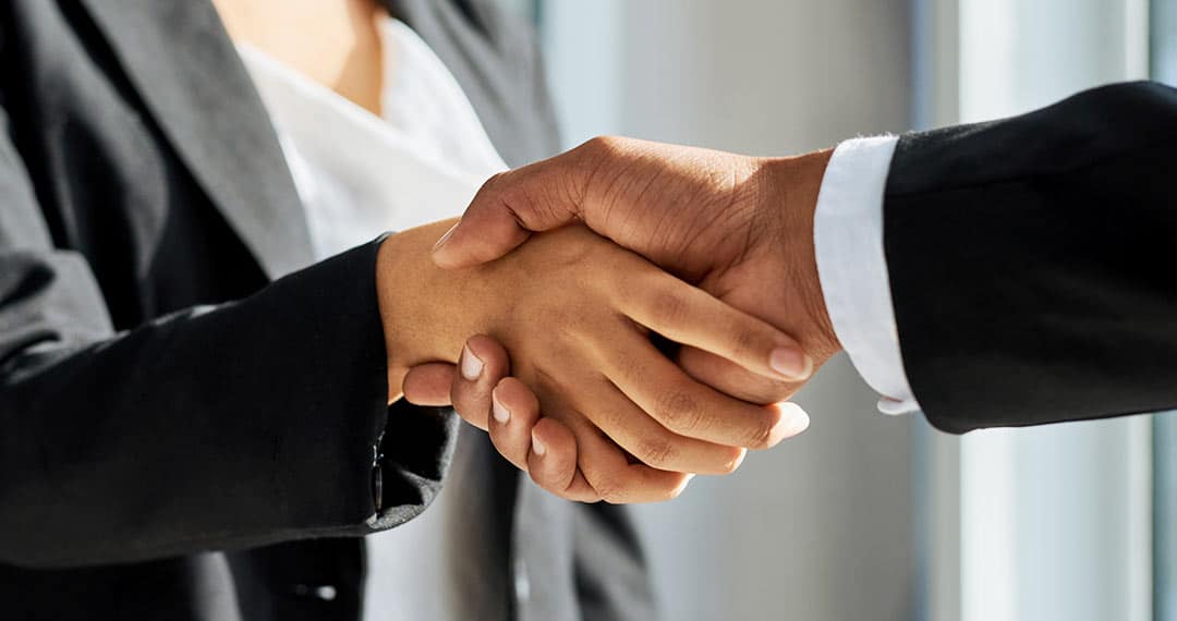 two people in business attire shaking hands