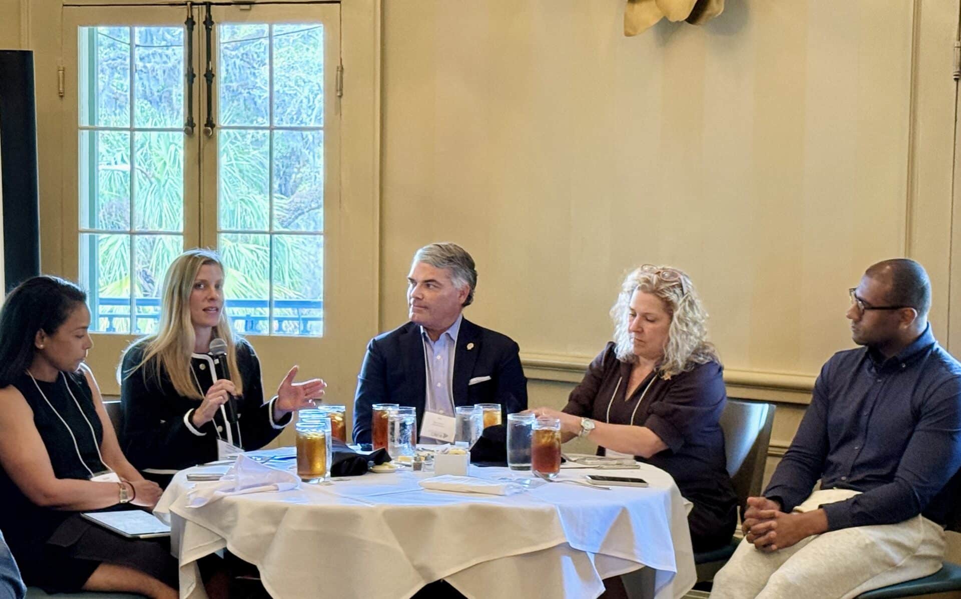 Catherine Blume, Director at Enhanced Capital, speaking at a table to others