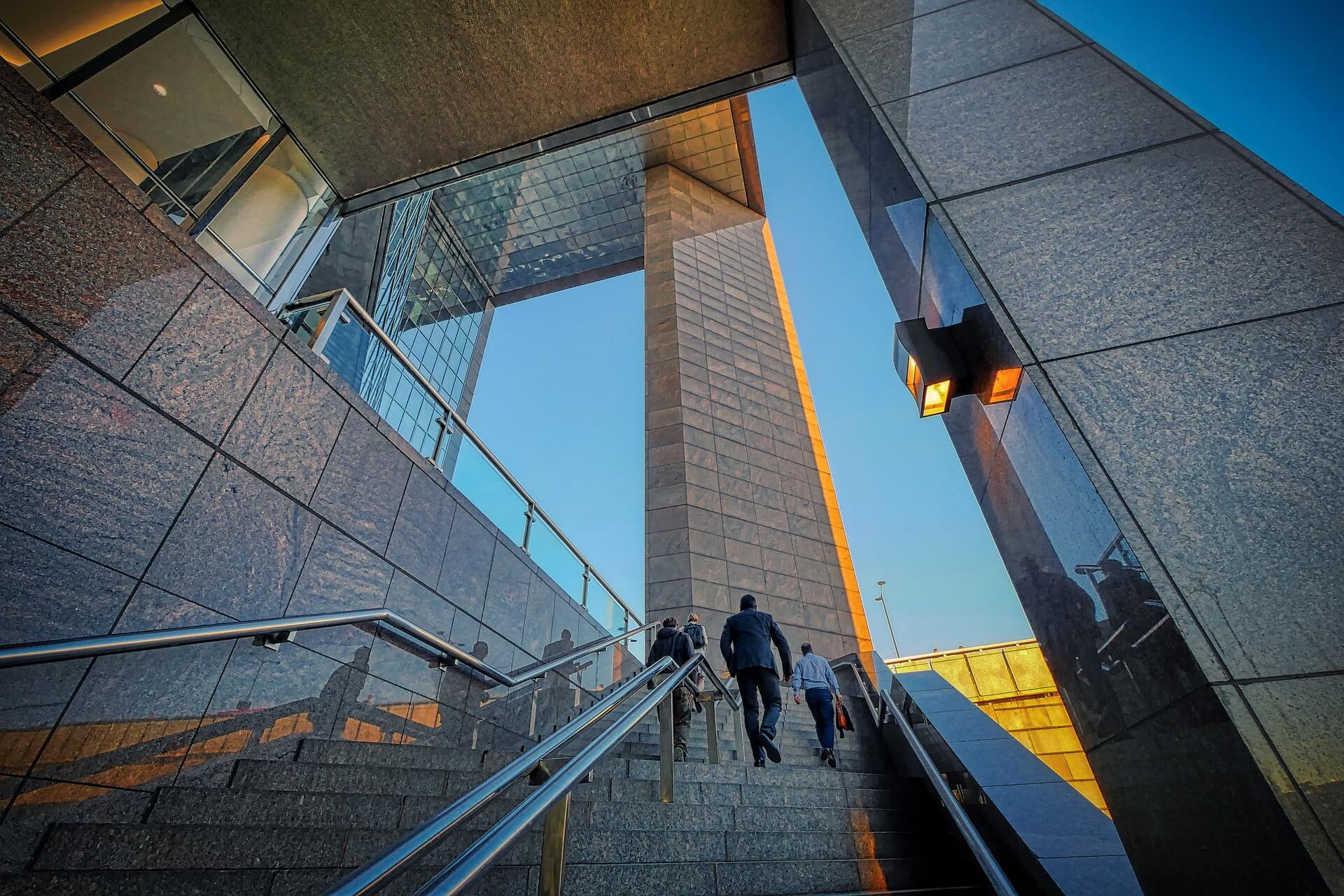 People walking up staircase in modern city building