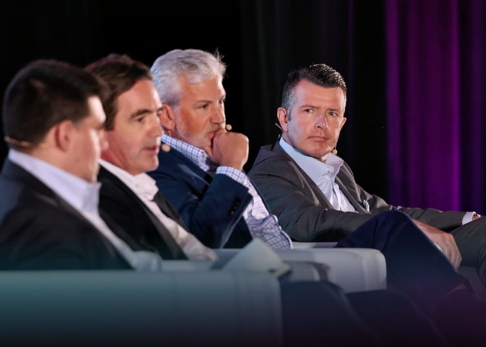 Luke Sarsfield speaking on stage with three other industry experts